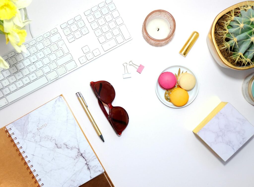 A flat lay view of a modern desk with a laptop, a notebook with ideas, and a cup of coffee, representing a digital side business.