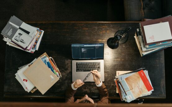 A software developer types on a laptop, with glowing lines representing an AI neural network superimposed over the image.