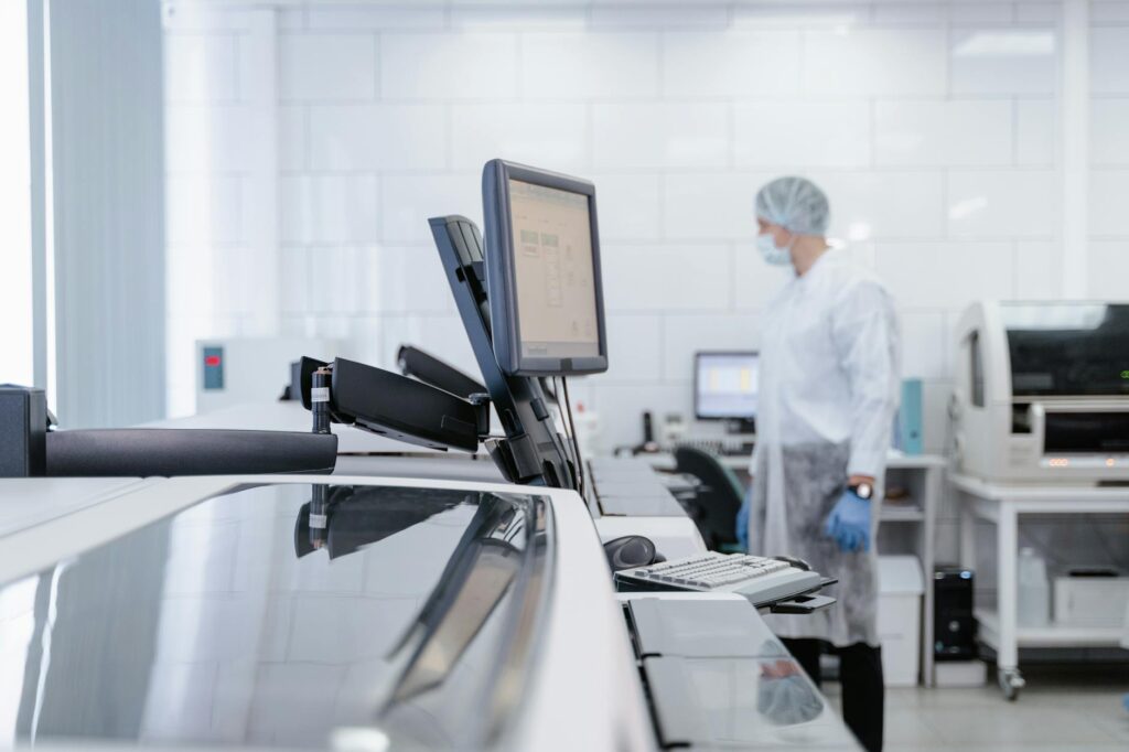 A diverse team of scientists in a lab coats collaborating around a computer screen showing complex molecular data for AI-driven drug discovery.