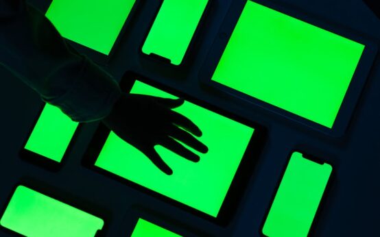 A close-up of a human finger interacting with a holographic display showing complex data and AI analytics.