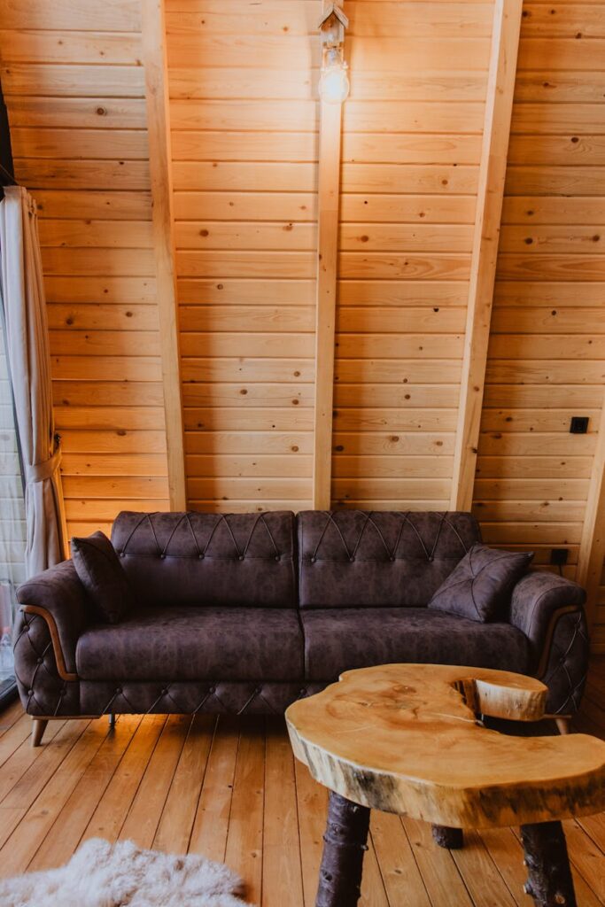 A rustic wooden cabin nestled among tall pine trees, with smoke coming from the chimney.