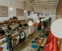 A freelancer sitting at a cafe table, working on a laptop displaying social media analytics.