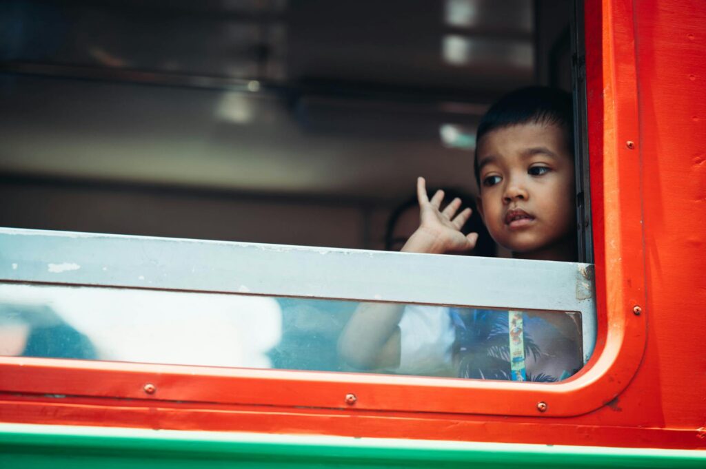 A student pauses from studying to gaze thoughtfully out a large window, taking a mental break.