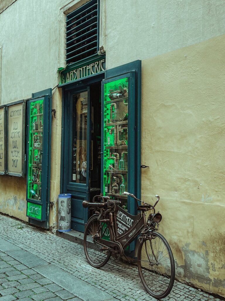 A narrow, charming cobblestone street in a historic European town, lined with colorful buildings and flower boxes.