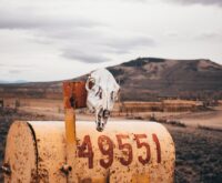 A winding road through a lush green valley marking a serene international border.