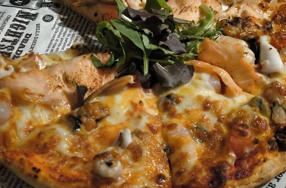 A beautifully plated grilled salmon fillet sits next to a colorful assortment of roasted asparagus, cherry tomatoes, and lemon slices.