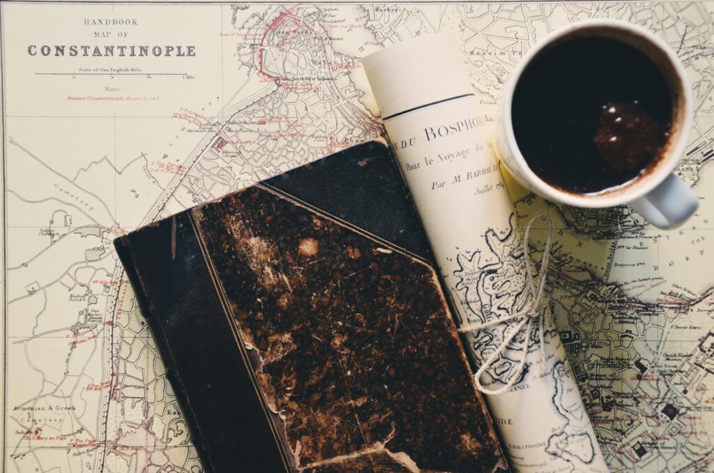 A woman meticulously plans her vacation, writing in a journal next to a world map and a cup of coffee.