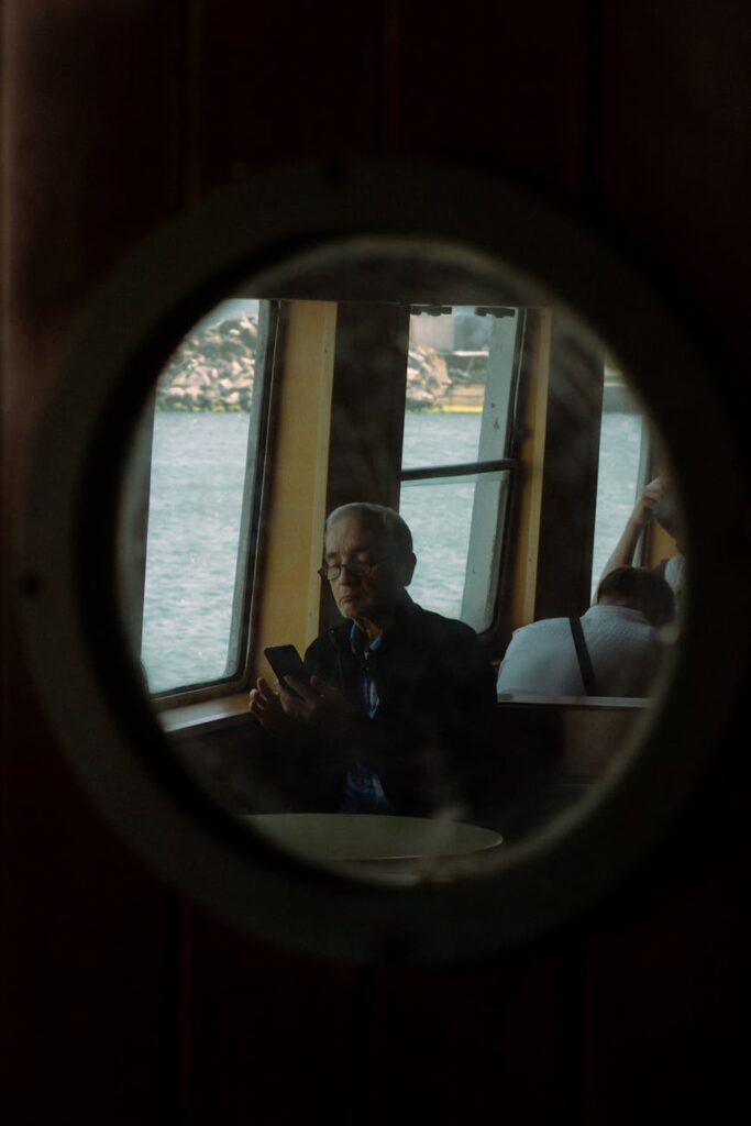 A pensive student takes a break from studying in a quiet library, gazing out a large window at the campus.