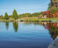 A solitary gondola navigating a narrow Venetian canal shrouded in ethereal morning fog.