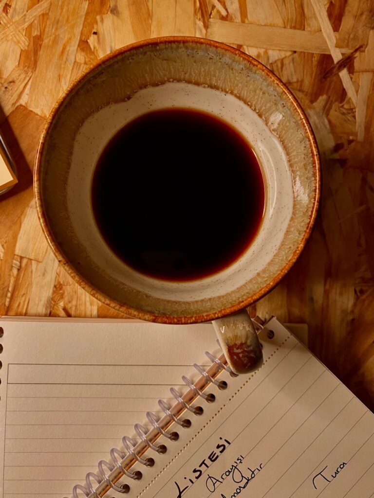 A thoughtful student sitting at a desk, looking at a notepad split into 'Pros' and 'Cons' columns.