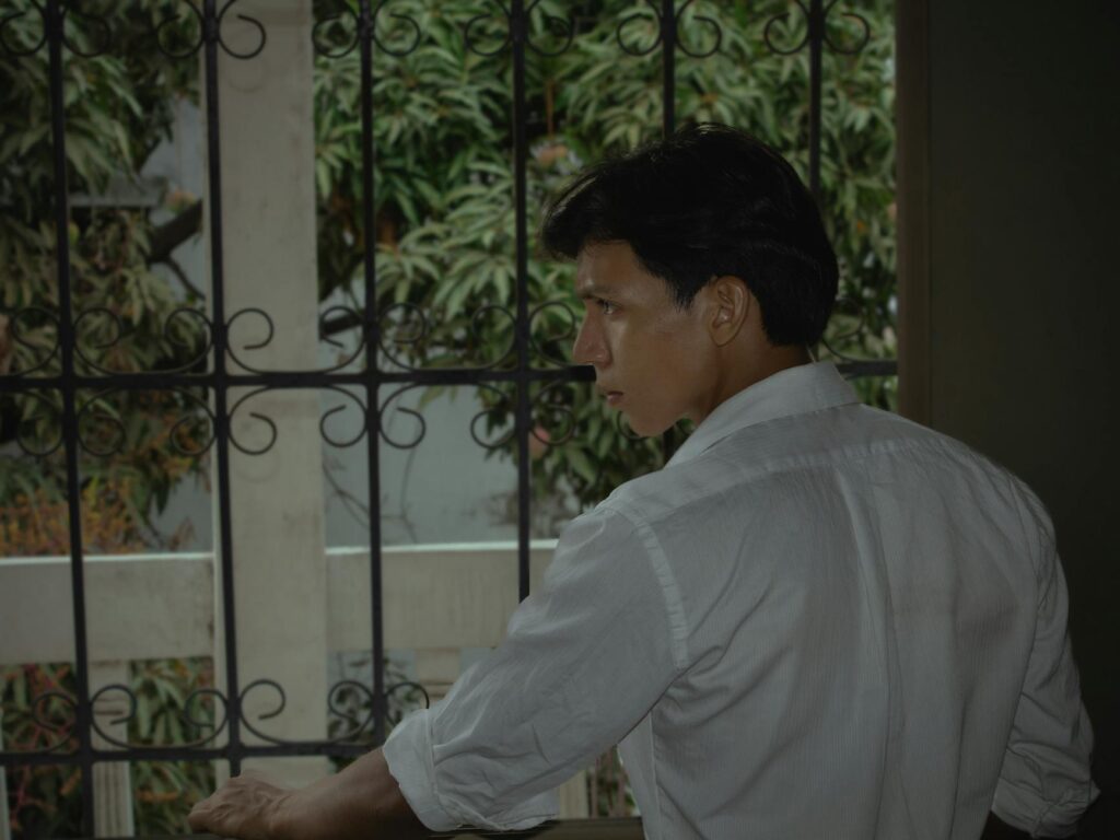 A serene woman with eyes closed, wearing headphones and sitting in an airplane seat by the window as the sun rises.