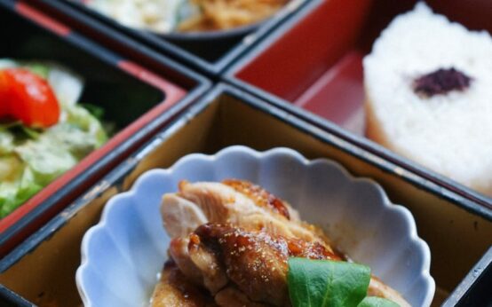 Top-down view of several glass meal prep containers filled with grilled chicken, quinoa, and roasted broccoli.