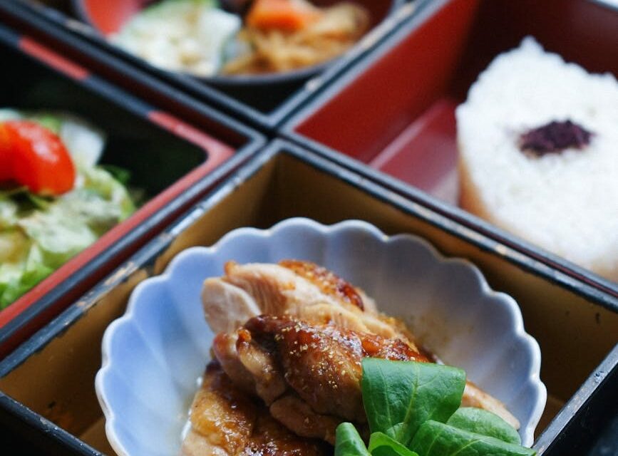 Top-down view of several glass meal prep containers filled with grilled chicken, quinoa, and roasted broccoli.