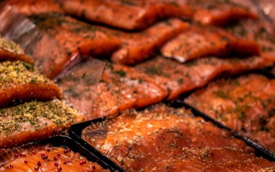 A vibrant array of colorful spices displayed in woven baskets at a crowded outdoor market.
