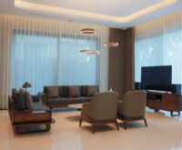 A woman smiling as she enjoys a cup of coffee in a comfortable airport lounge chair.