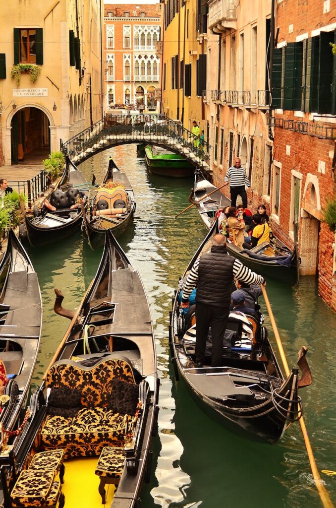 The reflection of colorful, historic buildings on the calm water of a quiet back canal in Venice.