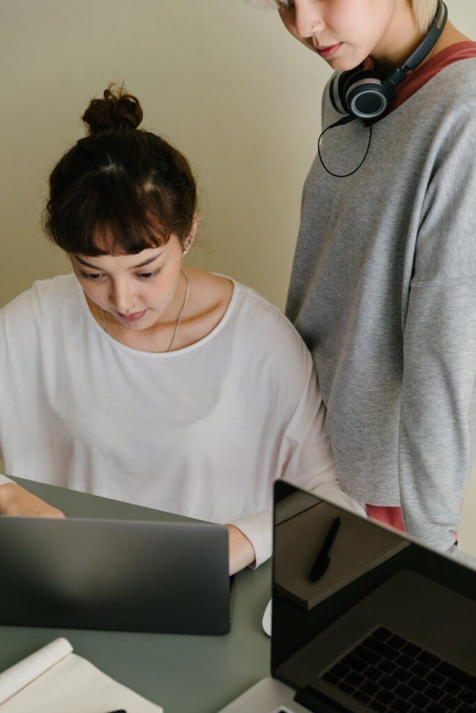 A university student smiling as they drag and drop files into a clearly labeled folder system on their computer.