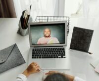 A focused student organizing digital files on a laptop at a neat and tidy wooden desk.