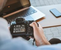 A man and a woman in business attire shaking hands across a conference table, sealing a strategic partnership.
