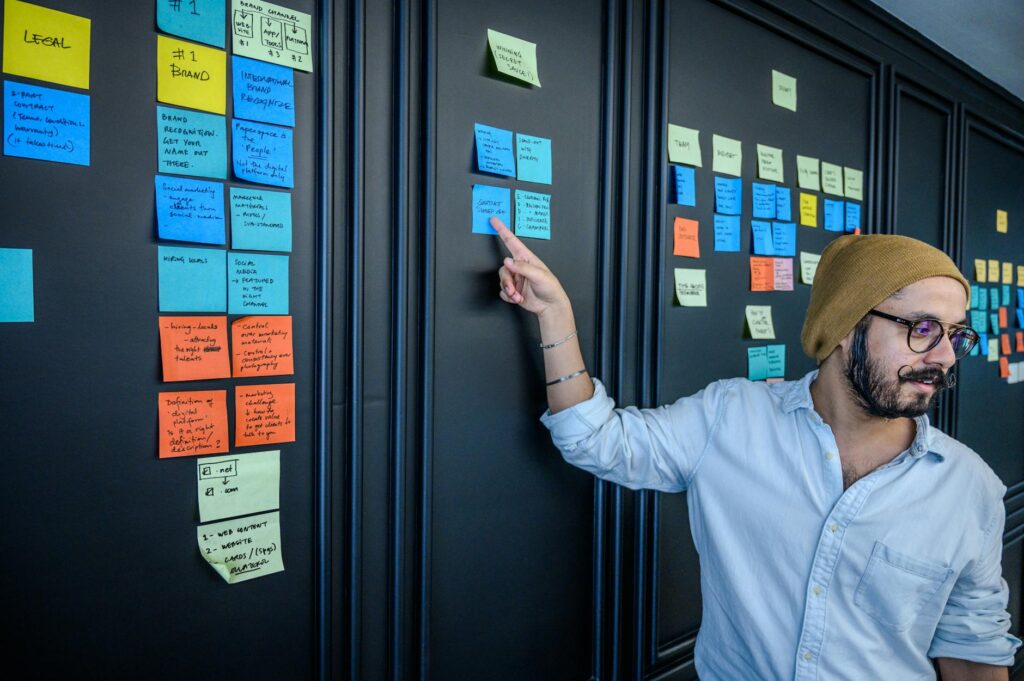 A close-up of a wall covered in colorful sticky notes with business ideas written on them.