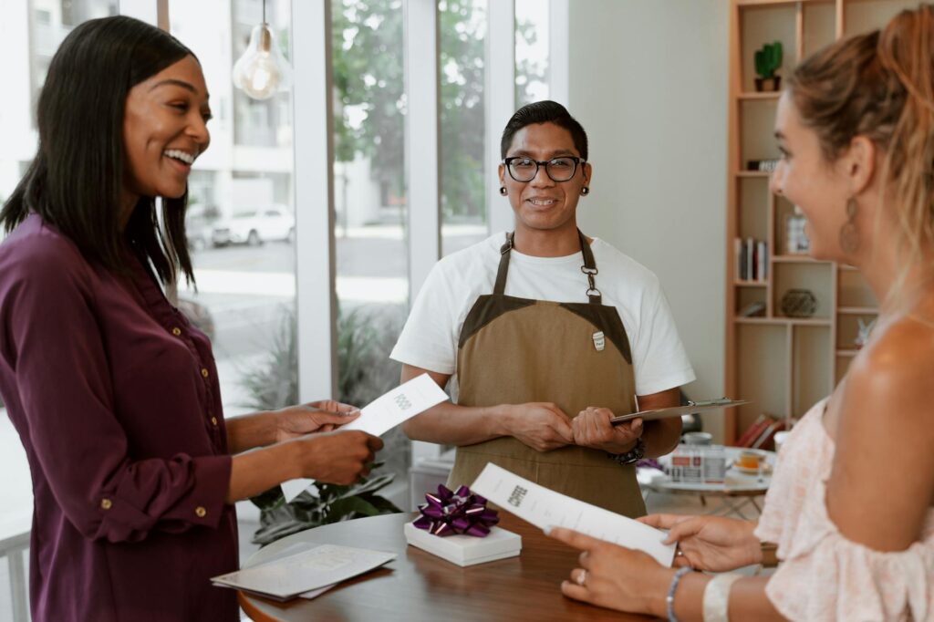 A happy customer shaking hands with a small coffee shop owner, representing strong brand loyalty.