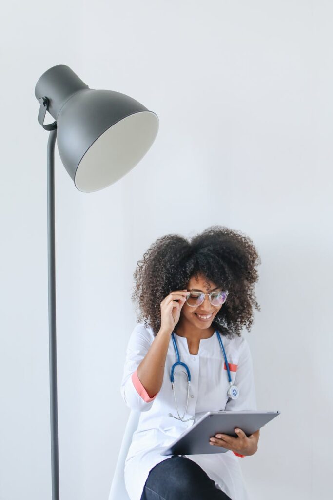 A happy woman receiving a payment notification on her tablet while sitting at her desk.