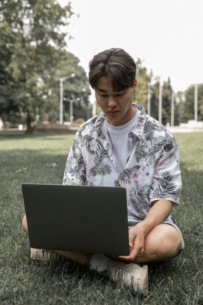 A student with a hand on their forehead, showing a moment of stress while looking at their computer.