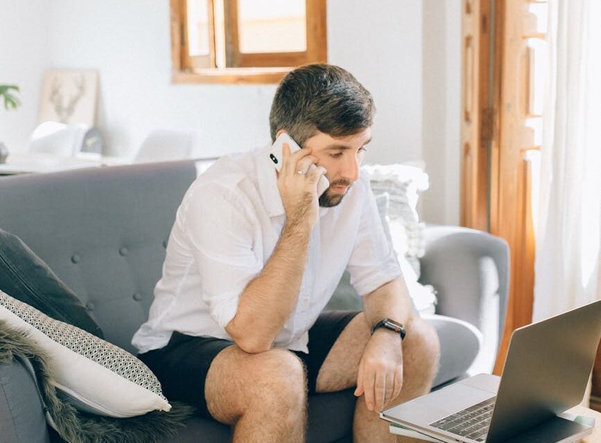 A commuter plans their trip on a smartphone while riding a train, with scenic countryside visible through the window.