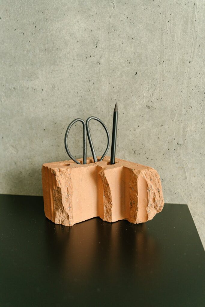 A close-up shot of a bright yellow rubber duck standing out in a sea of identical grey ducks.