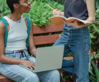 A diverse group of university students work together on a complex engineering model in a well-lit workshop.