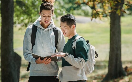 A diverse group of university students gathered around a holographic interface, working together on a complex project.