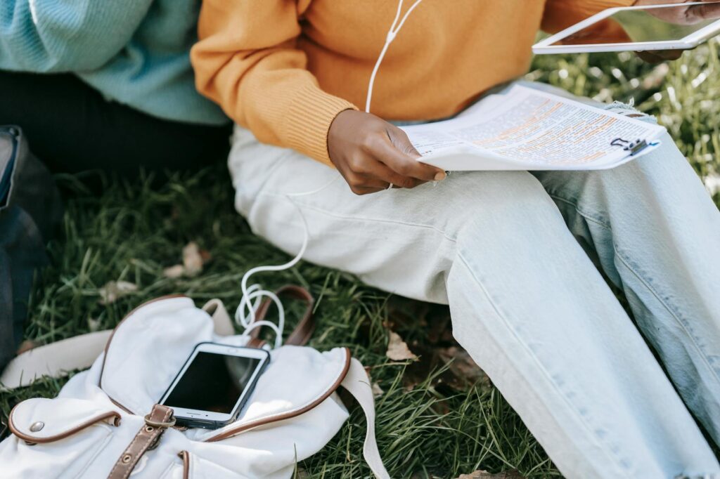 Close-up of a female student's hands holding a smartphone displaying a calming meditation app interface.