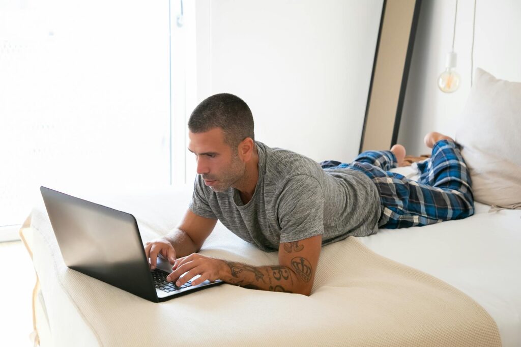 A person comfortably working from a home office, smiling at their laptop, representing earning money online.