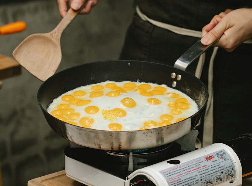 A person holding a box of cereal and carefully reading the nutrition facts label on the side.