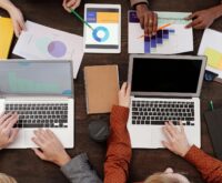 A student focused on their laptop which displays a rising financial graph, symbolizing online income.