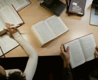 A focused student coding on their laptop in a well-lit, quiet library setting.