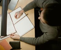 A young student focused on their laptop in a well-lit room, preparing for an online exam.
