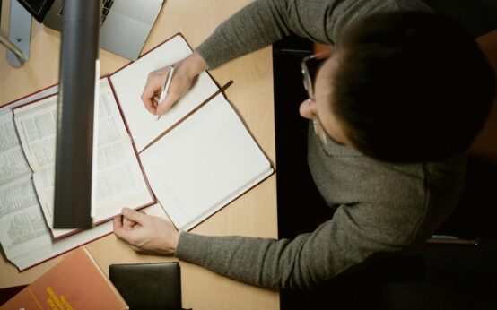 A young student focused on their laptop in a well-lit room, preparing for an online exam.