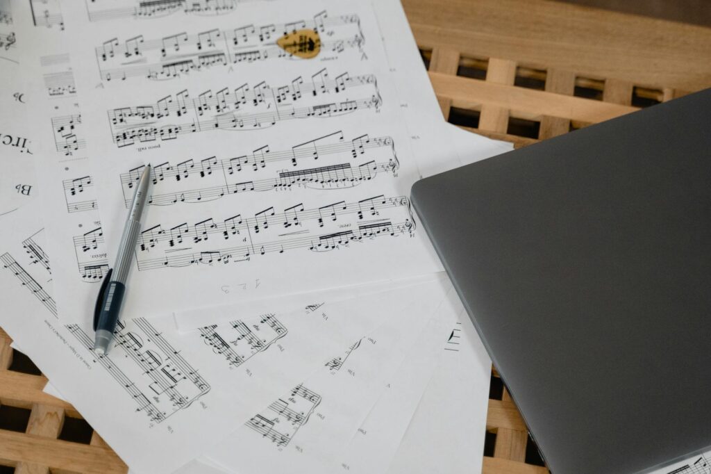 Close-up of a music student's hands playing a melody on a digital piano with sheet music in the foreground.