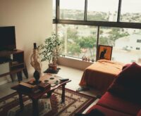 A top-down view of travel essentials like a passport, headphones, and a notebook arranged neatly on a surface.