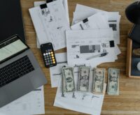 An accountant looking stressed while working on financial reports late at night in an office.