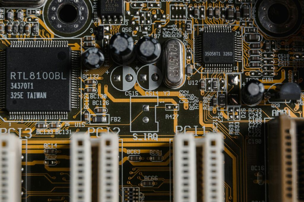 A detailed close-up shot of a student's hands carefully soldering a component onto a green circuit board.