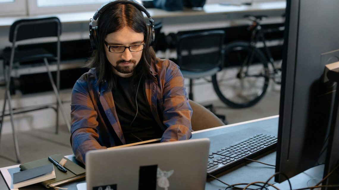 A developer working on a complex headless commerce architecture with code on multiple monitors.
