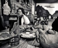 A person relaxing with their feet propped up, enjoying a healthy green smoothie.