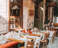 A quiet, narrow cobblestone street in an old European city, bathed in the warm, golden light of sunrise.