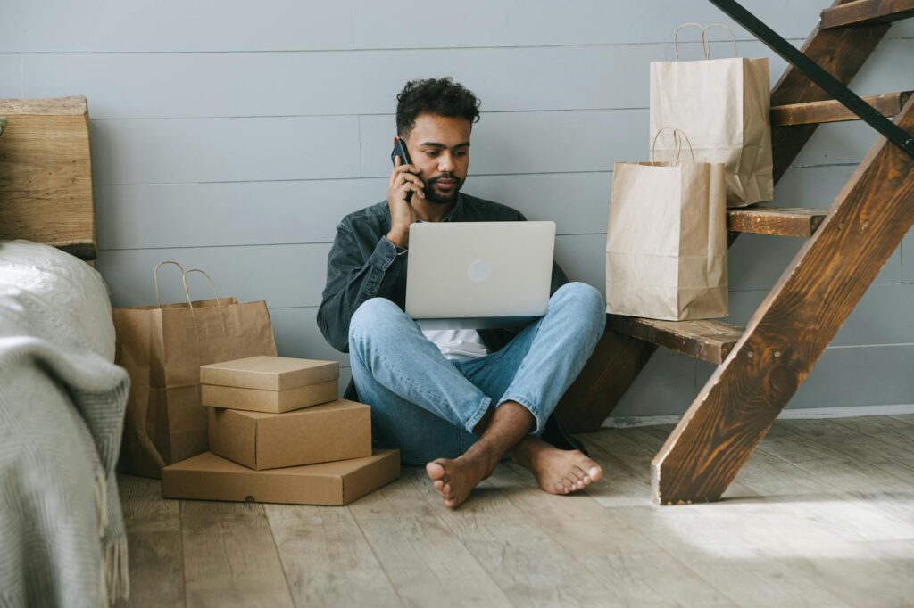 A focused young student works on their startup idea on a laptop, surrounded by the energetic atmosphere of a coffee shop.
