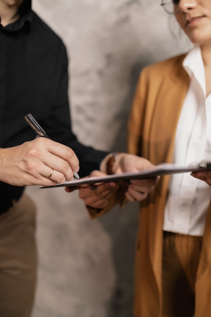 Close-up shot of a hand signing a formal business contract, symbolizing the first step of ASC 606.