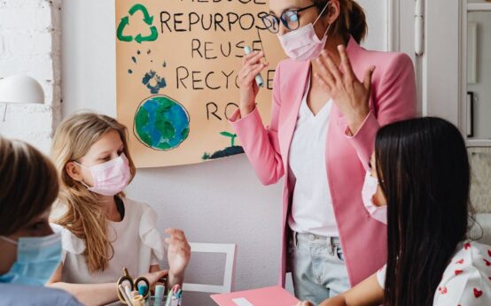 A diverse group of students working together on a project in a bright, modern classroom.