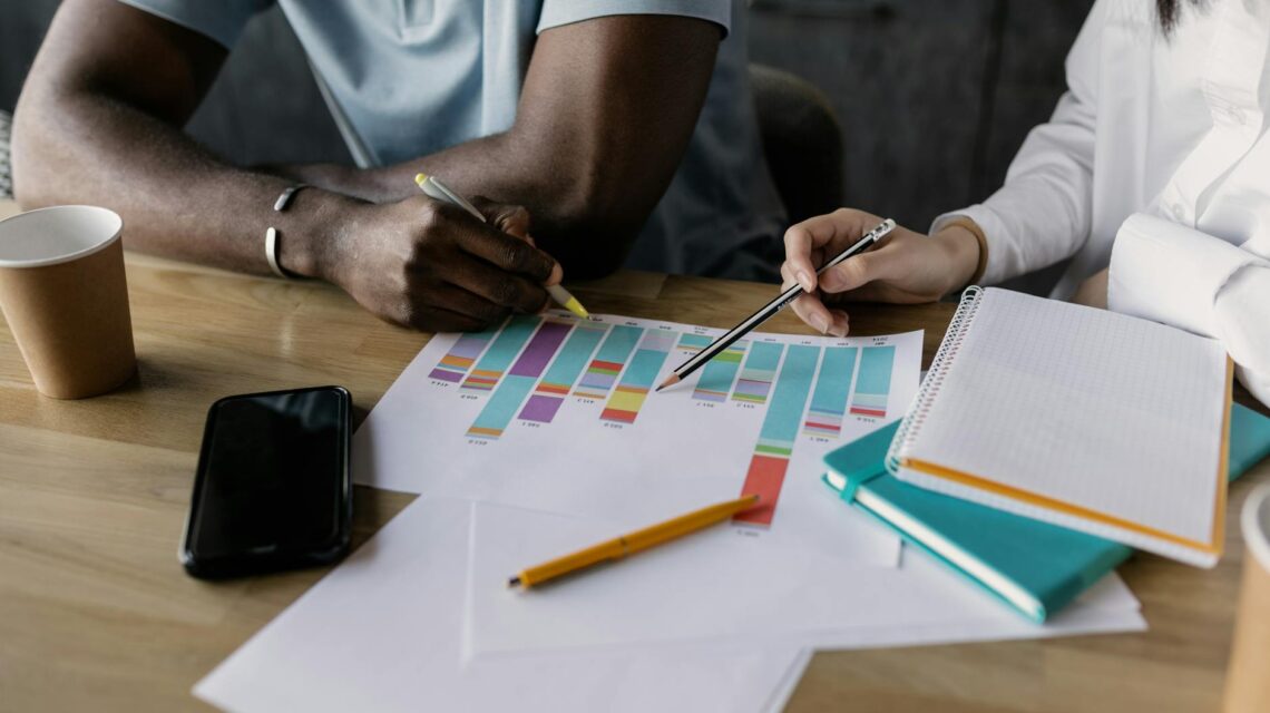 A diverse team of financial analysts pointing at a dynamic graph during a strategy meeting.