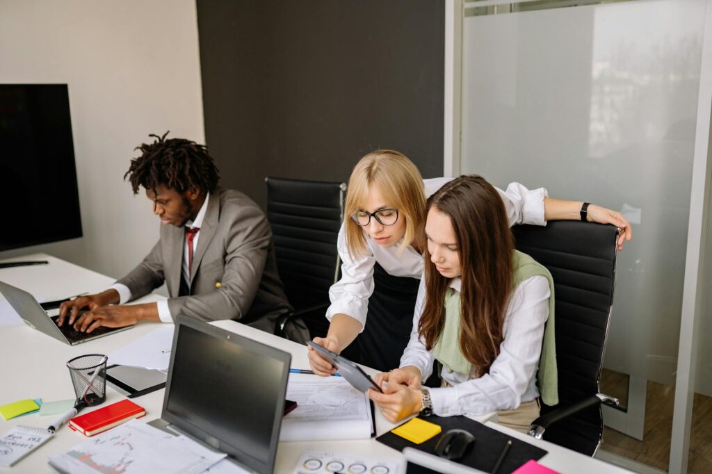 A diverse team of professionals brainstorming around a table in a bright, modern office.
